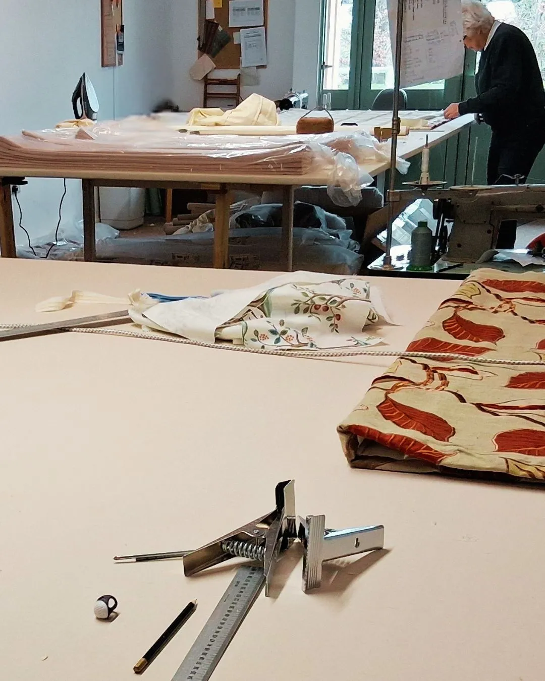 Fabric being cut and prepared at the upholstery workbench